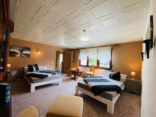 オシャースレーベンにあるSternhausのベッド2台とテーブルが備わるホテルルームです。