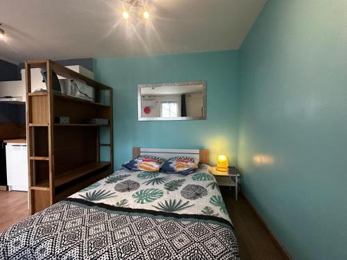 1 dormitorio con 1 cama con pared azul en Le Panorama-centre ville, en Niort