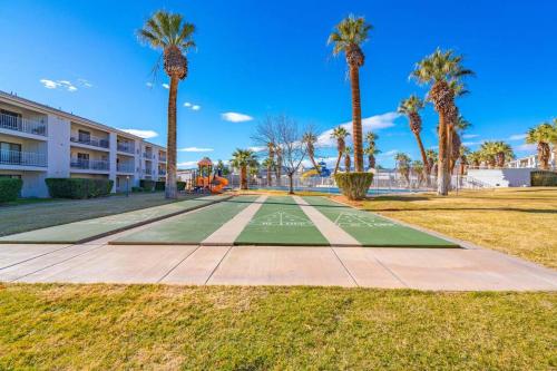 a tennis court in front of a building with palm trees at Perfect Family Escape - 3 Bed Condo with Pools in St. George