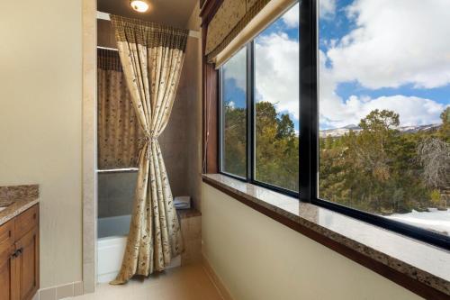 a bathroom with a large window with a view of trees at Catamount Lodge in Ridgway