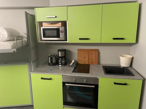 a kitchen with green cabinets and a microwave at Burghaus-Cochem in Cochem