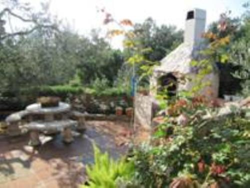 a garden with a picnic table and a building at Hetenika in Sućuraj