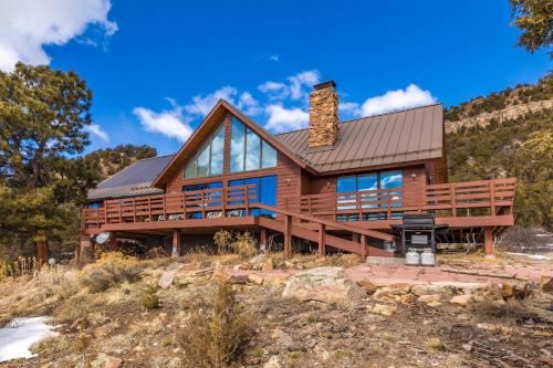 a log home on a hill with a roof at Catamount Lodge in Ridgway