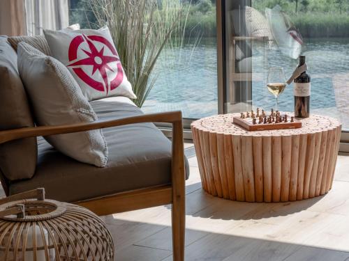 uma sala de estar com um sofá e uma mesa com um copo de vinho em Wohntraum direkt am See em Stansstad