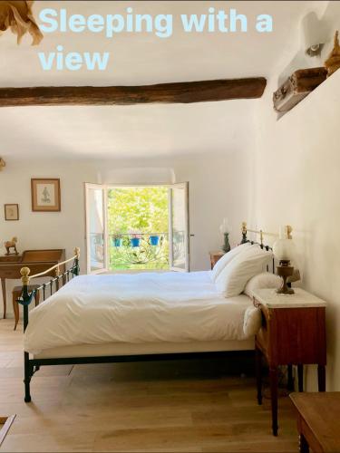 - une chambre avec un lit, une fenêtre et un piano dans l'établissement L’écrin de Cléama, à Figanières