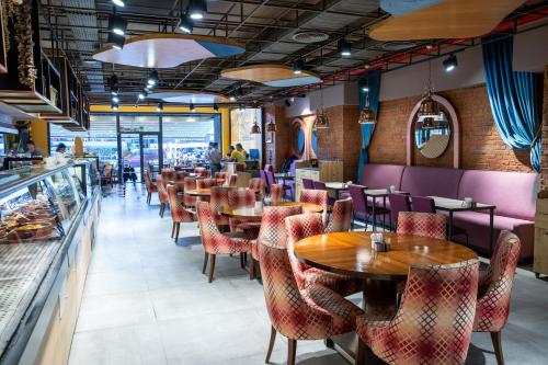 فندق وأجنحة غراند أراس في إسطنبول: مطعم بطاولات خشبية وكراسي حمراء