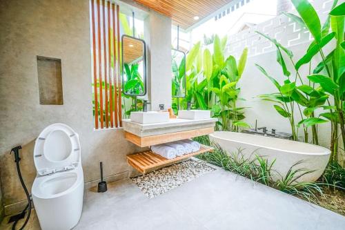 ein Badezimmer mit Toilette, Waschbecken und Badewanne in der Unterkunft Tiny Villa Nyanyi - 2 BR Architectural Villa 4 mins to Beach in Tanah Lot