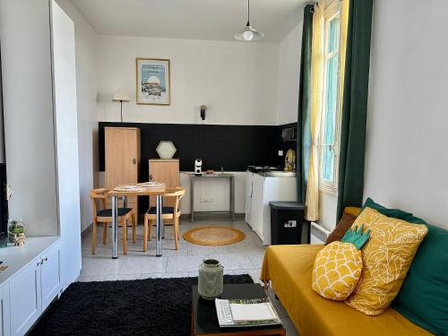 un salon avec un canapé et une table dans l'établissement Cosy studio - Terrasse ensoleillée - 3 mn Monaco, à Roquebrune-Cap-Martin