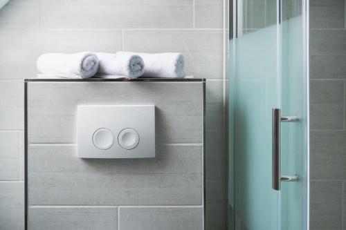 a bathroom with a towel dispenser on a wall at Aparthotel Lenau in Hannover