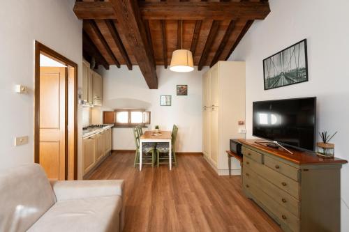a living room with a couch and a tv and a table at Era Rental Apartments in Florence