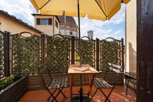 a table and chairs on a balcony with an umbrella at Era Rental Apartments in Florence