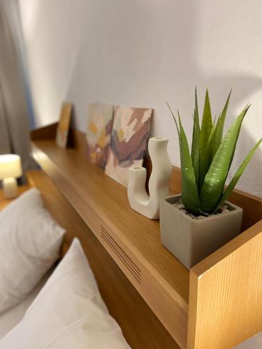 a wooden shelf with plants on top of a bed at Zentrale Wohnung Gmunden Alte Bäckerei in Gmunden