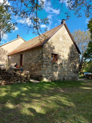 una antigua casa de piedra con una pared de piedra en Kuća za odmor Vučipolje, en Tomislavgrad