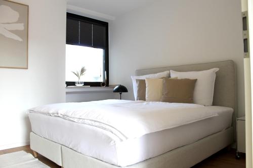 una camera bianca con un grande letto bianco e una finestra di Boutique Wohnung mit Domblick a Paderborn