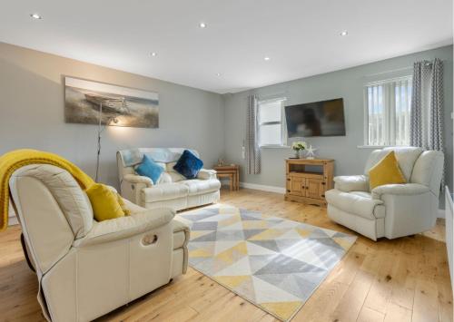 sala de estar con 2 sillas blancas y alfombra en Benone Getaways en Derry