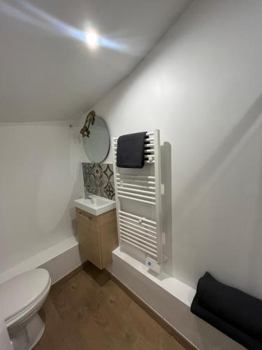 une salle de bain blanche avec des toilettes et un lavabo dans l'établissement Studio Louis XIII, à Rouen