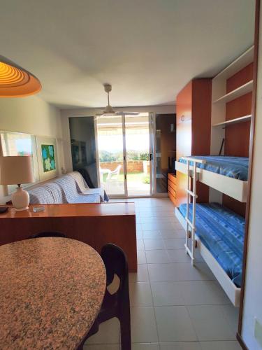 a room with two bunk beds and a table and a dining room at Holiday Homes Marina apartments in Punta Ala