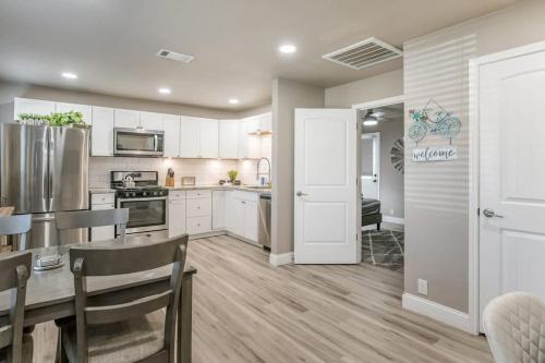 a kitchen with white cabinets and a table and chairs at Amazing Hot tub l Sleeps 14 in Amarillo