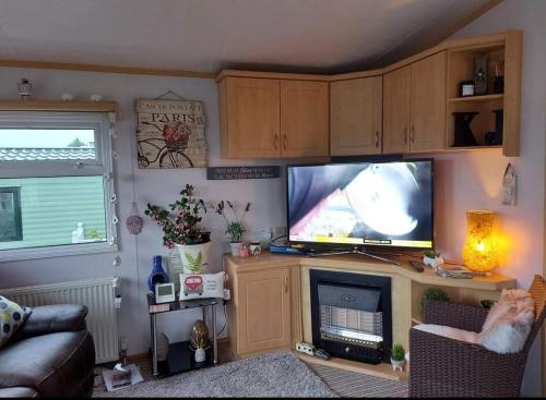 a living room with a flat screen tv on a entertainment center at Three Peaks View. in Clitheroe