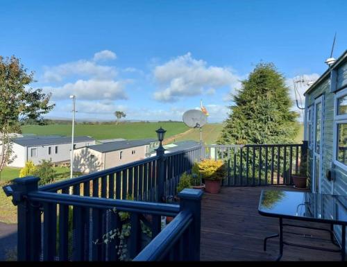 a balcony with a table and a view of a field at Three Peaks View. in Clitheroe