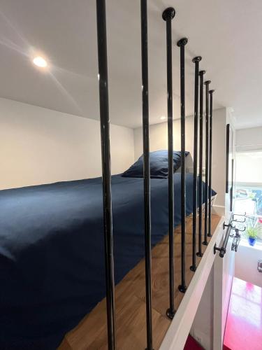 a bedroom with a bed with black poles in it at Studio Louis XIII in Rouen