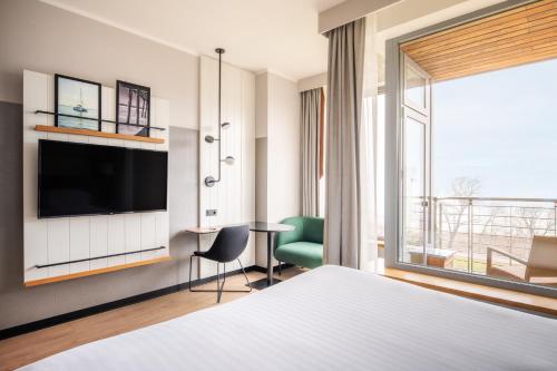 Habitación de hotel con cama, TV y mesa. en Sopot Marriott Resort & Spa en Sopot