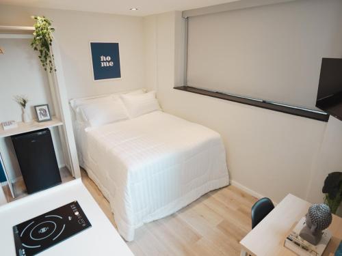 a bedroom with a white bed in a room at Apê Metrô Paulista in Sao Paulo