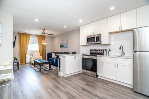 a kitchen with white cabinets and a living room at Close to everything fun Free Parking LM1704 in Atlanta
