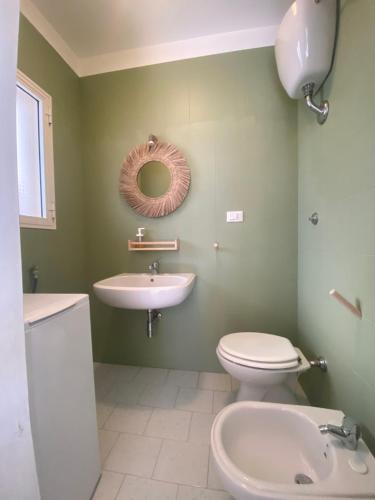 a bathroom with a sink and a toilet and a mirror at villa adua in Torre Santa Sabina
