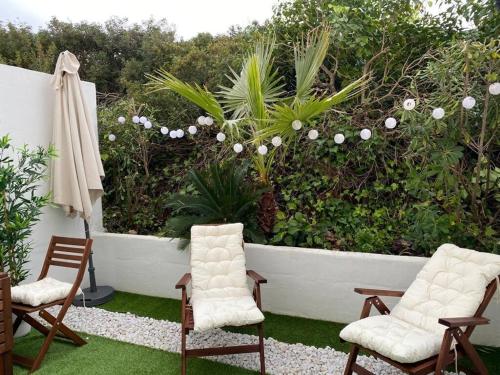 un jardin avec deux chaises et un mur orné de plantes dans l'établissement Apartamento 315 Castell Sol CB, à Arenal d'en Castell