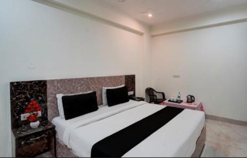um quarto com uma grande cama branca num quarto em gold stays hotel near IGI international airport em Nova Deli