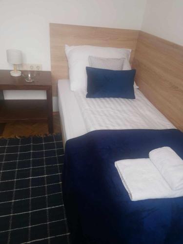 a bed with blue and white pillows and a table at Eisenerzer Apartments - Radmeisterhaus in Eisenerz