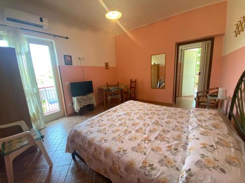 - une chambre avec un lit et une télévision dans l'établissement Michelangelo's House, à Gioiosa Marea