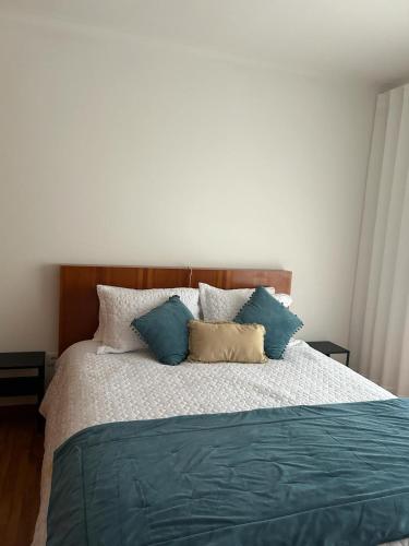 a bedroom with a bed with blue and white pillows at Beach House in Vila do Conde