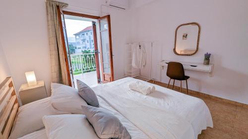 a bedroom with a white bed and a mirror at Archzante boutique villa in Kalamaki