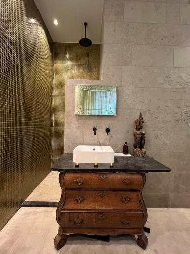 a bathroom with a sink on top of a wooden dresser at Boutique amsterdam B&B in Amsterdam