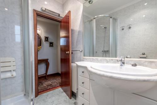 a white bathroom with a sink and a shower at Horia apartment by People Rentals in Bilbao