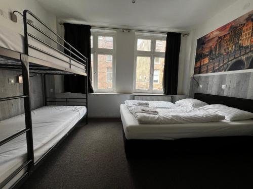 a bedroom with two bunk beds and a window at Budget Trianon Hotel in Amsterdam
