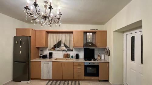 una cocina con armarios de madera y una lámpara de araña en Manousos Guest House en Heraclión