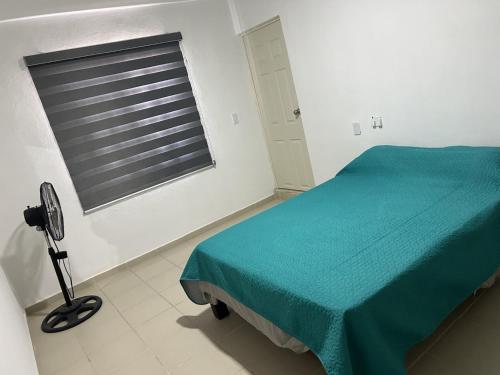 ein Schlafzimmer mit einem grünen Bett und einem Fenster in der Unterkunft Alojamiento privado con seguridad 3 in Tepic
