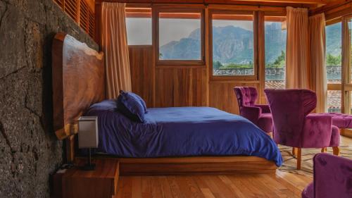 1 dormitorio con 1 cama con sillas moradas y ventana en La Hacienda Tepoztlán Awarded - Firenze Entremuros, en Tepoztlán