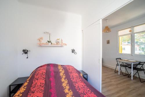 une chambre avec un lit et une table dedans dans l'établissement Petit Bonheur - Appt climatisé proche de la mer, à Argelès-sur-Mer