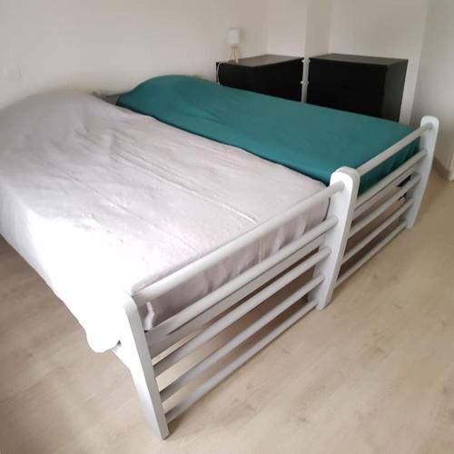 - un lit blanc dans une chambre dotée de parquet dans l'établissement Maison avec terrasse Classée 3*, à La Brée-les-Bains