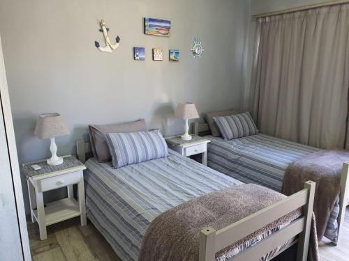a bedroom with two beds and two tables with lamps at Dolly@Skuitbaai in Eersterivierstrand