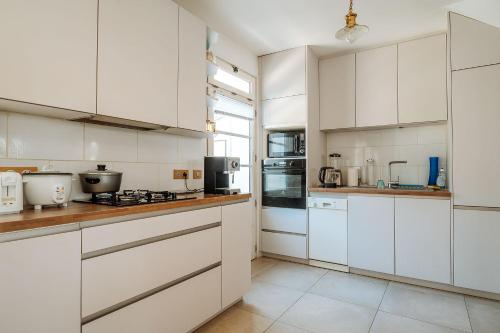 une cuisine blanche avec des armoires et des appareils blancs dans l'établissement House Ty-Matelot Daleth at 2 min foot in the water, à Saint-Malo