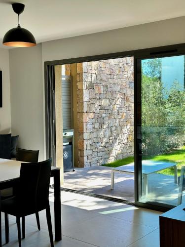 d'une salle à manger avec une porte coulissante en verre s'ouvrant sur une terrasse. dans l'établissement Entre mer et golf à Beauvallon face à Saint-Tropez, à Grimaud