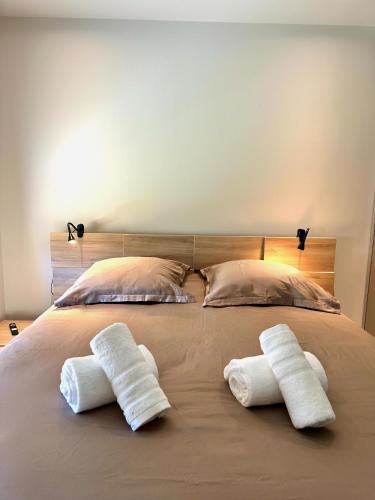 - 2 serviettes sur un lit avec 2 oreillers dans l'établissement Entre mer et golf à Beauvallon face à Saint-Tropez, à Grimaud