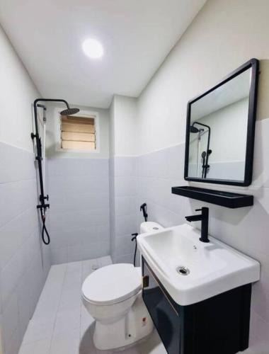 a bathroom with a toilet and a sink and a mirror at Have a good Rest in Kajang