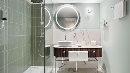 La salle de bains est pourvue d'un lavabo et d'un miroir. dans l'établissement Hotel Bristol Berlin, à Berlin
