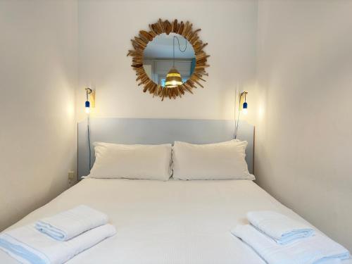 a bedroom with a large white bed with a mirror at Un Passo dal Mare in Zoagli